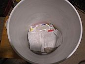 An almost full ziploc bag of kitty litter, a new pack of baby wipes and a small roll of plastic wastebasket bags fits in the space of a 5 gal. bucket when another bucket is nested on top, allowing a full sized porta potty...