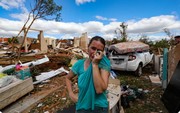 A resident of Rio Bonito do Iguacu in southern Brazil cries over debris of her house destroyed by a tornado with winds of up to 250 km/h on November 8, 2025 [Daniel Castellano/ AFP]...